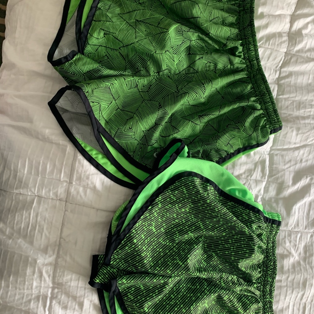 two pairs of green nike running shorts